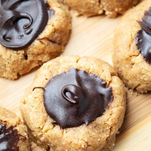 overhead view of keto sugar free peanut butter blossoms lined up together on parchment paper