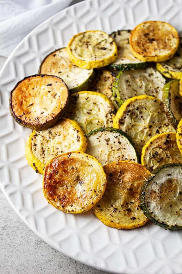 overhead view of oven baked roasted zucchini and squash on a white serving dish