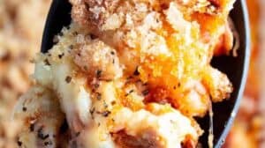 overhead view of serving spoon with keto chicken parmesan casserole with casserole in background