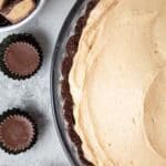 overhead view of keto peanut butter pie in a glass pie dish and 3 sugar free reese's mini cups next to it