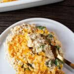 overhead view of serving of chicken cauliflower rice casserole on a white plate with a gold fork