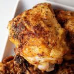 overhead view of ready to serve crispy air fryer garlic parmesan chicken thighs on a white plate
