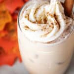 overhead view of a glass of keto iced pumpkin spice latte with topped with whipped cream and vanilla stick