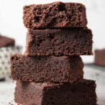 sideview of four keto brownies stacked atop each other and ready to serve
