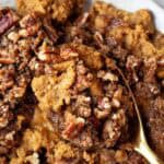 overhead view of keto sweet potato casserole on a white serving dish and gold serving spoon