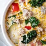 overhead view of zuppa toscana soup in a large ceramic pot with a soup ladel