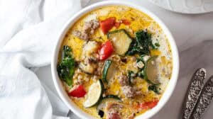 overhead view of ready to serve keto zuppa toscana soup in a white bowl