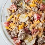 overhead view of Big Mac salad in a glass serving bowl topped with Big Mac sauce