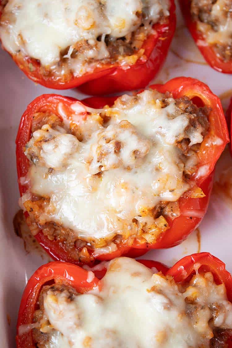 overhead view of keto Italian sausage stuffed peppers on a white serving dish