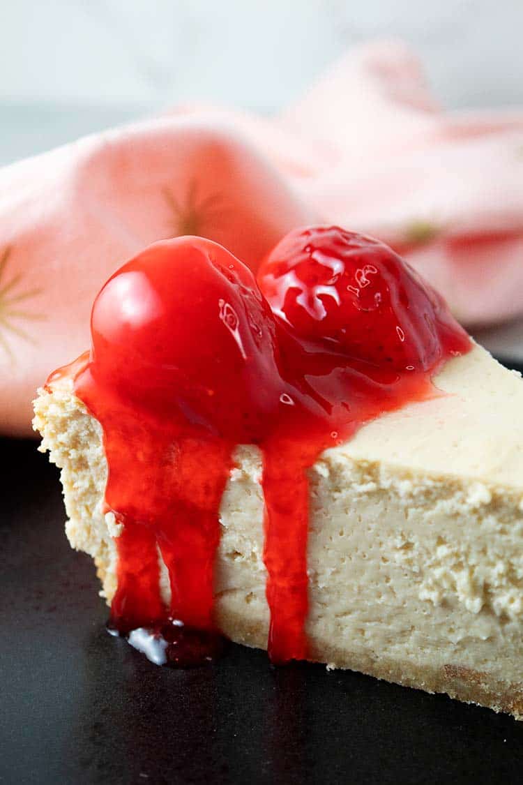 SideView Close -Up of Keto Strawberry Cheesecake on a black serving dish.