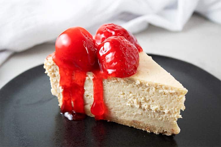 Side review of Keto Strawberry Cheesecake on a black serving dish.